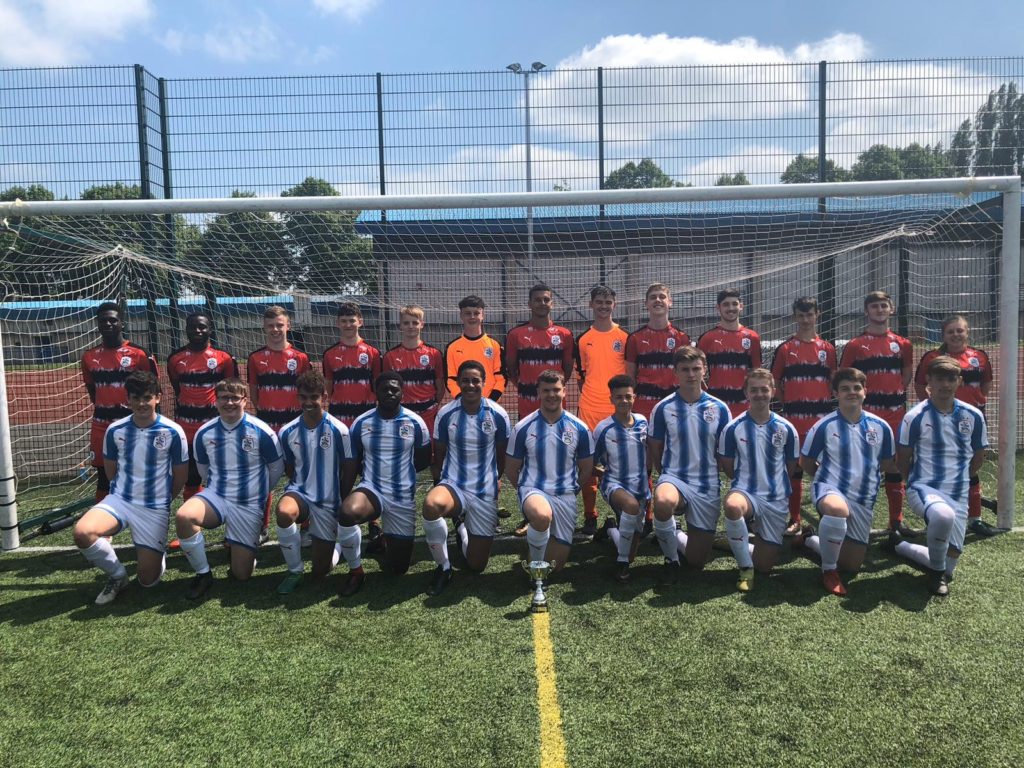 Group of male students in football shirts lined up for a group photograph