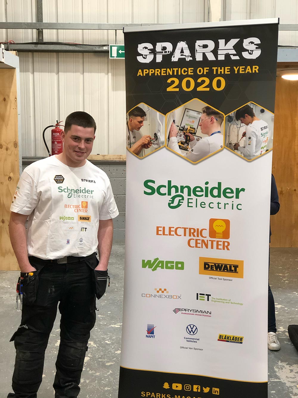 Electrical student stood next to a poster