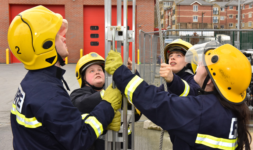 Students in uniform holding a ladder