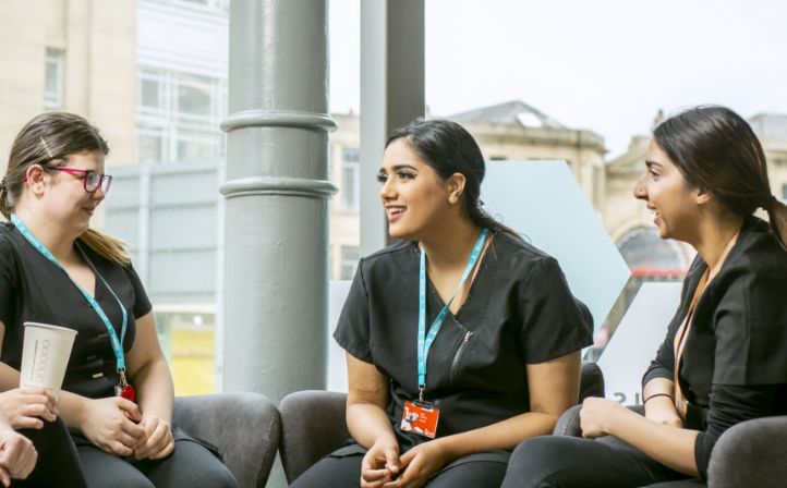 Three young beauticians sat around chatting and talking with one another