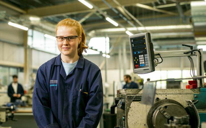 Female apprentice stood by a CNC milling machine