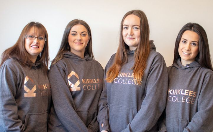 Four female apprentices wearing Kirklees College hoodies