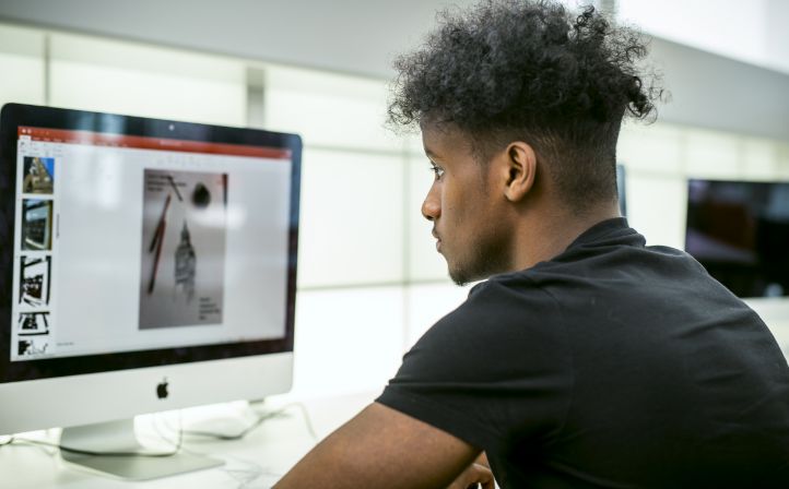 Male student designing graphics on an Apple iMac