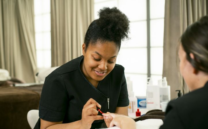 Female beauty student painting a ladies nails