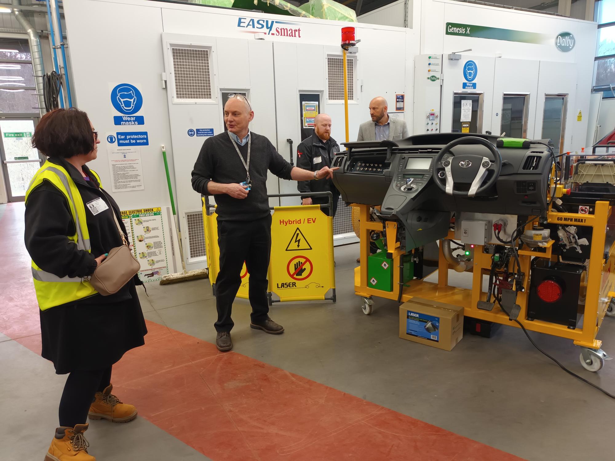 Kirklees college staff and event attendees in high vis jackets looking at the new Electric vehicle facilities