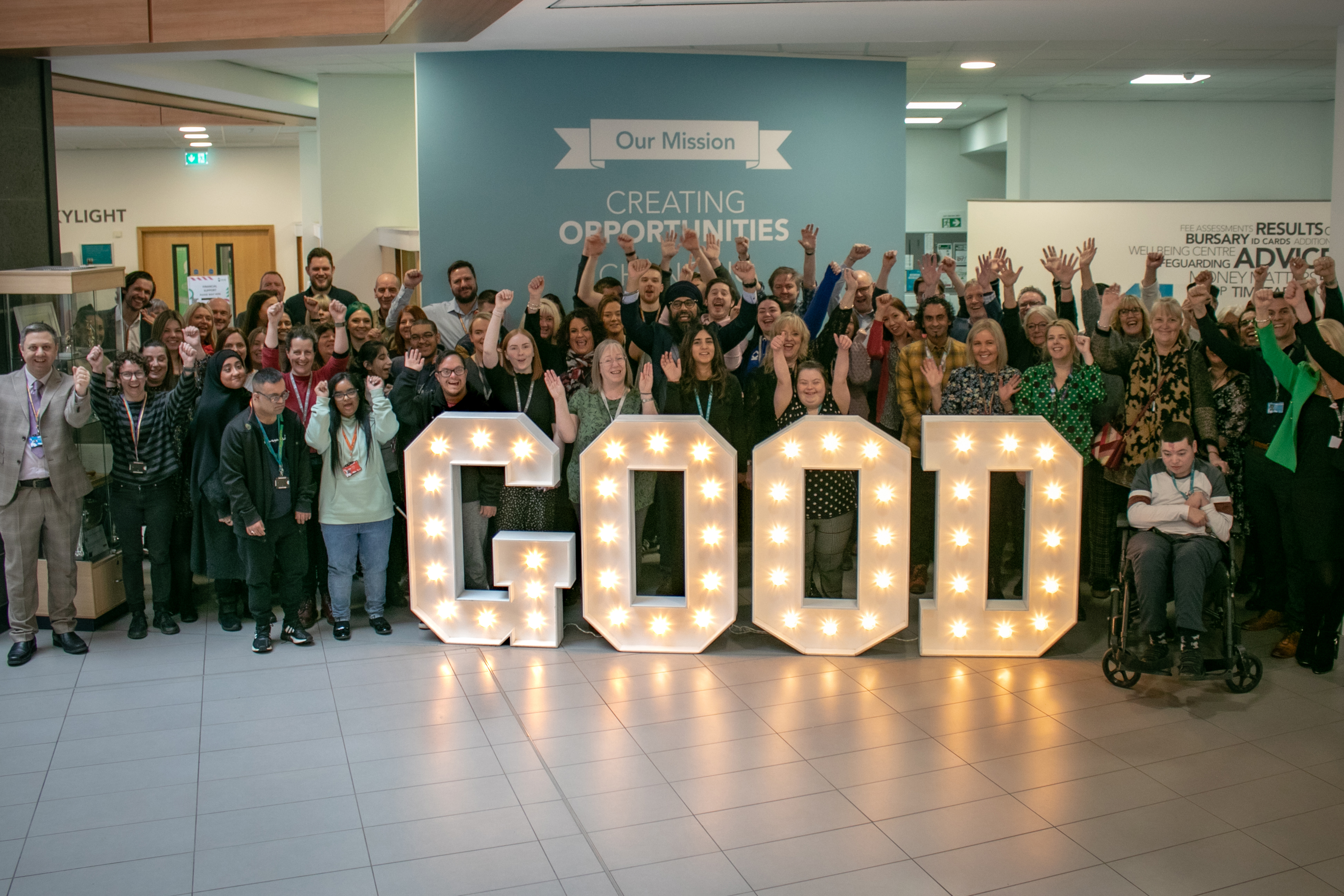 Students and staff stand behind letters spelling 'GOOD' to celebrate Ofsted result.
