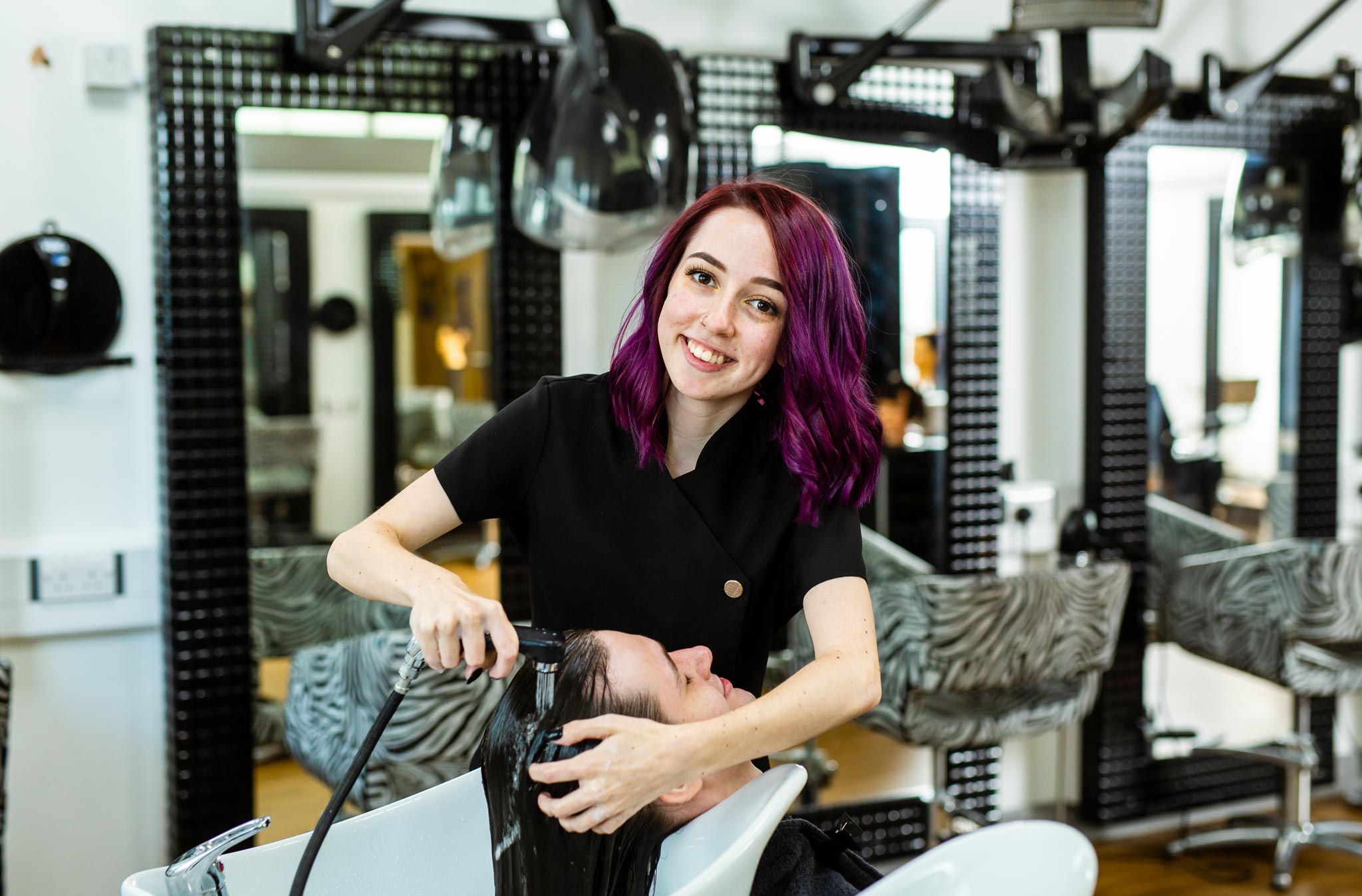 Barbering Student Washing Client's Hair Whilst Looking at the Camera