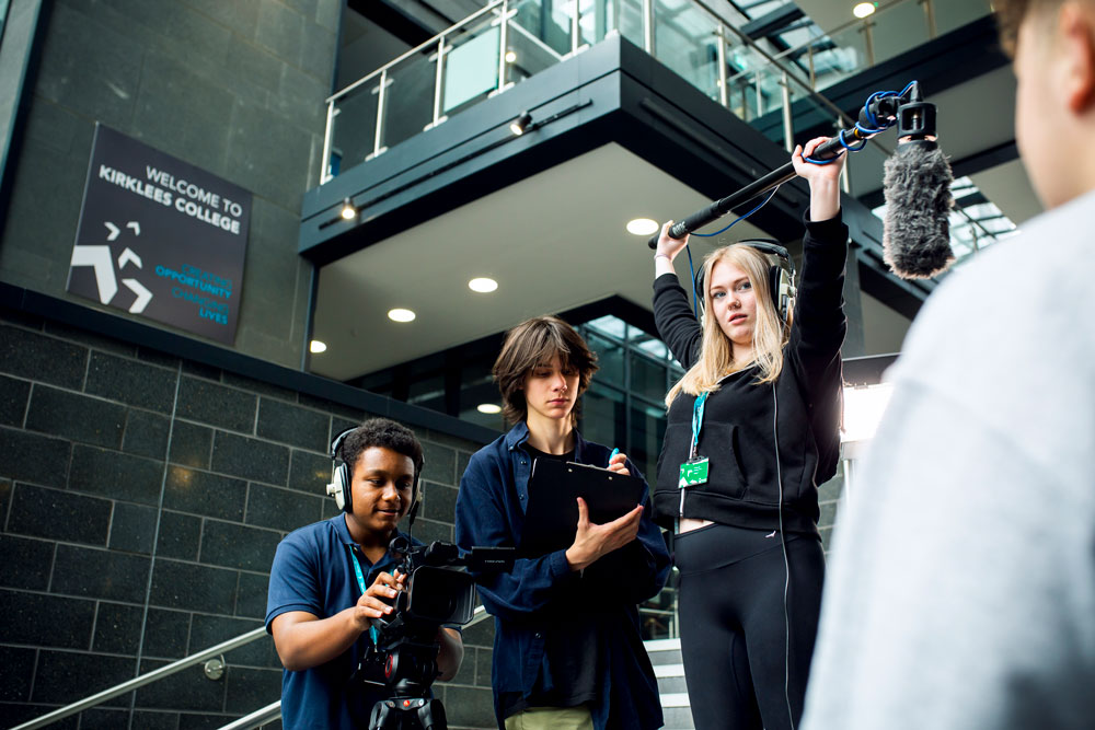 Media Students Interviewing Student Holding Clipboard, Microphone and Camera