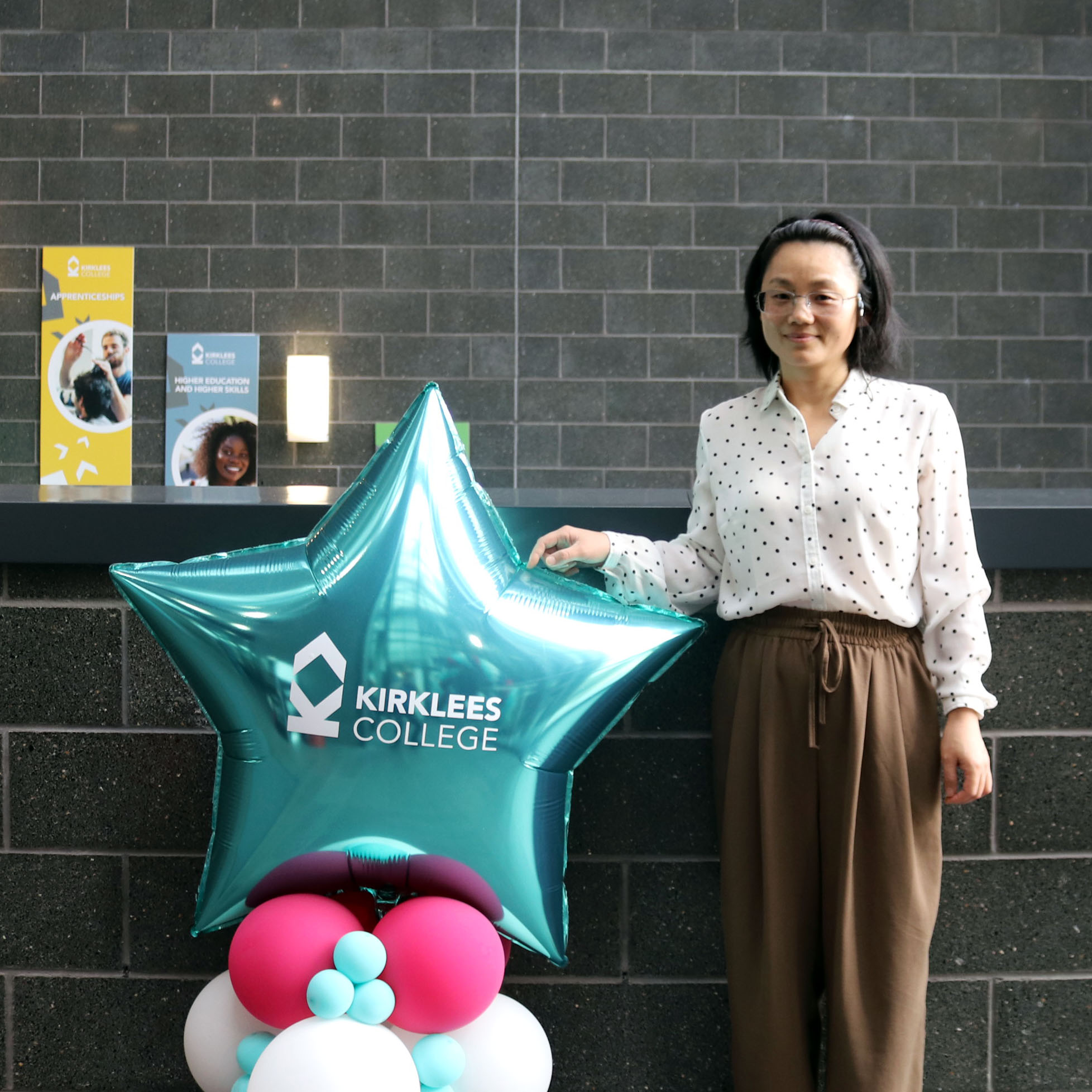 Kirklees College GCSE student poses next to balloons