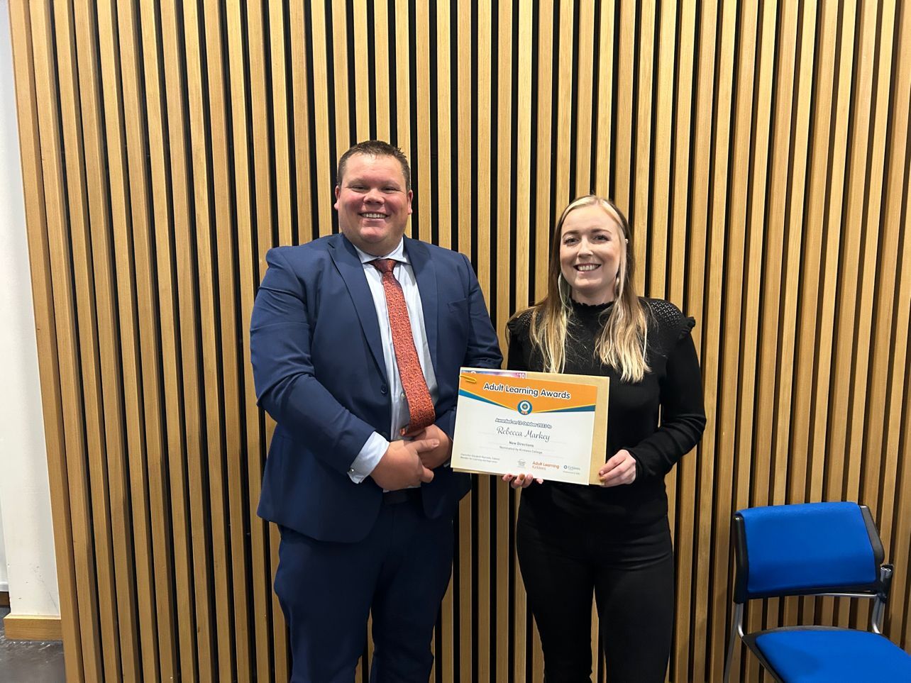 Graham (tutor) and Rebecca (plumbing apprentice) shake hands whilst holding award certificate