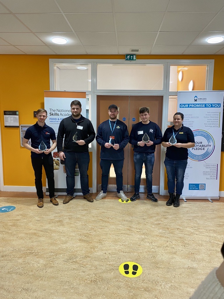 Food and Drink apprentices stand in a line holding their trophies