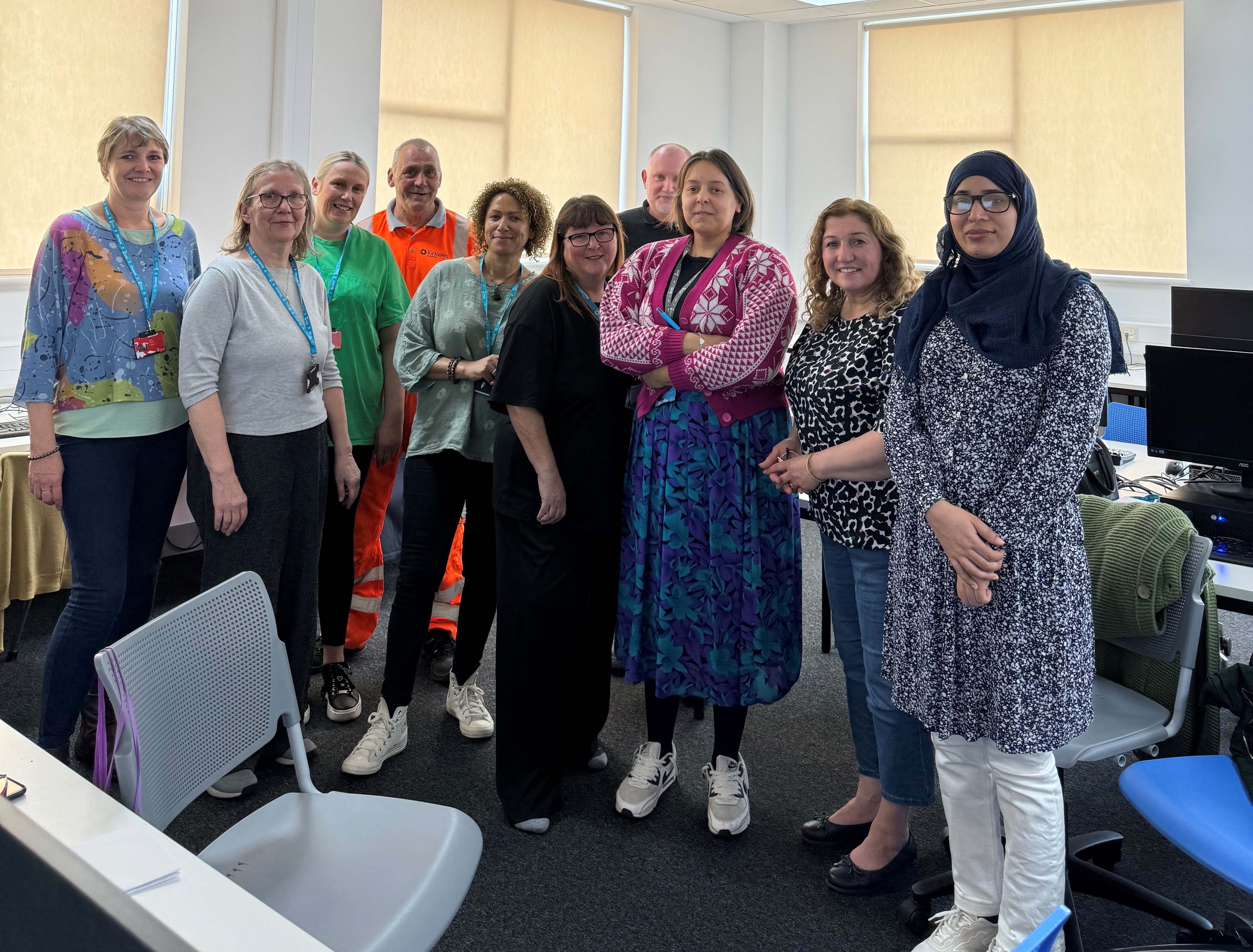 Adult learners stand in group in classroom