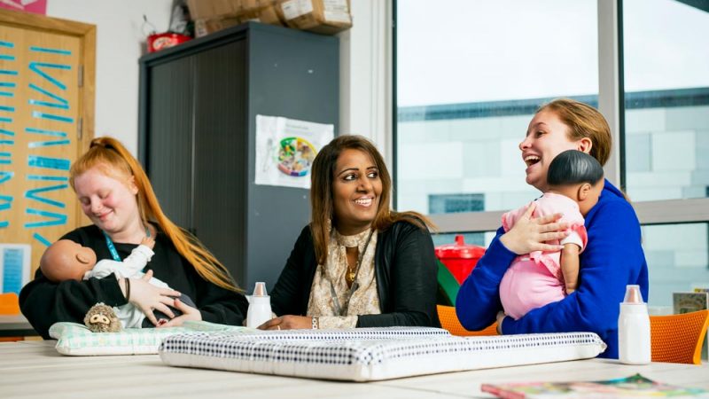 Early Years Students Nurturing Animatronic Baby and Smiling