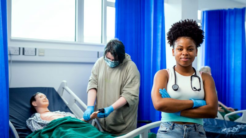 Health and Social Care Student in Full Equipment Looking at the Camera with Folded Arms