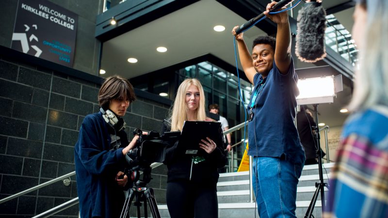 Media Students Interviewing Student Holding Clipboard, Microphone and Camera
