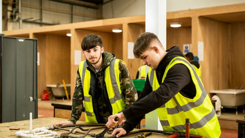 Two Male Plumbing Students Working on Pipe in Workshop at Brunel Construction Centre