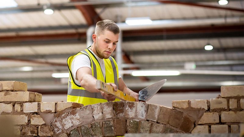 Young male student from Kirklees practising his bricklaying