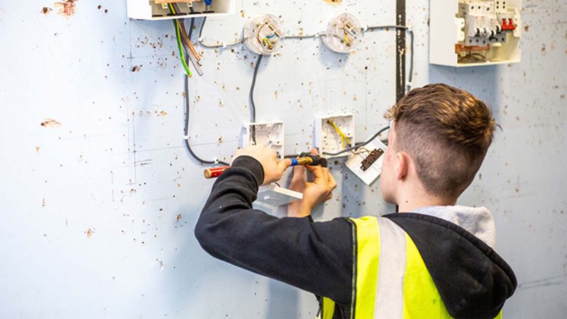 A young male apprentice practising his electrical wiring