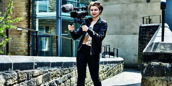 a female camera woman stood outside the huddersfield centre of Kirklees college