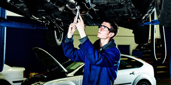 A young kirklees mechanic working underneath a car